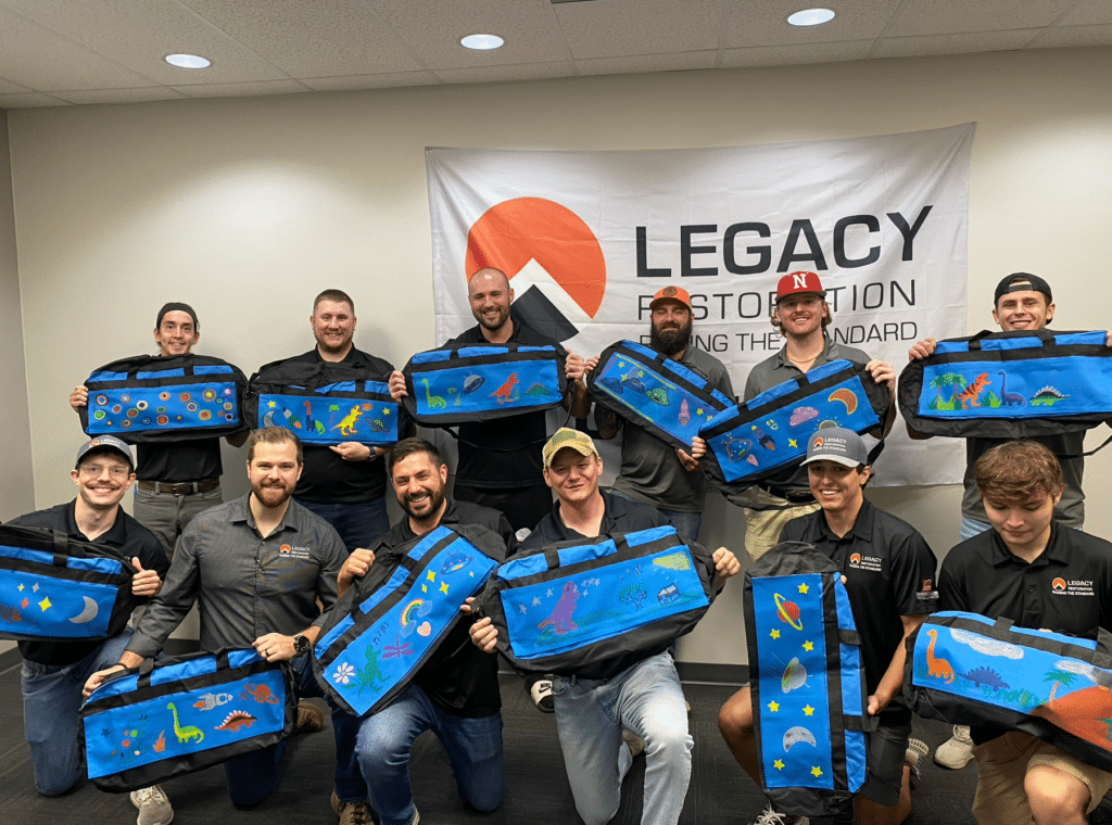 Omaha Legacy team posing with decorated Sweet Cases for the give back event - to be donated to Project Harmony.